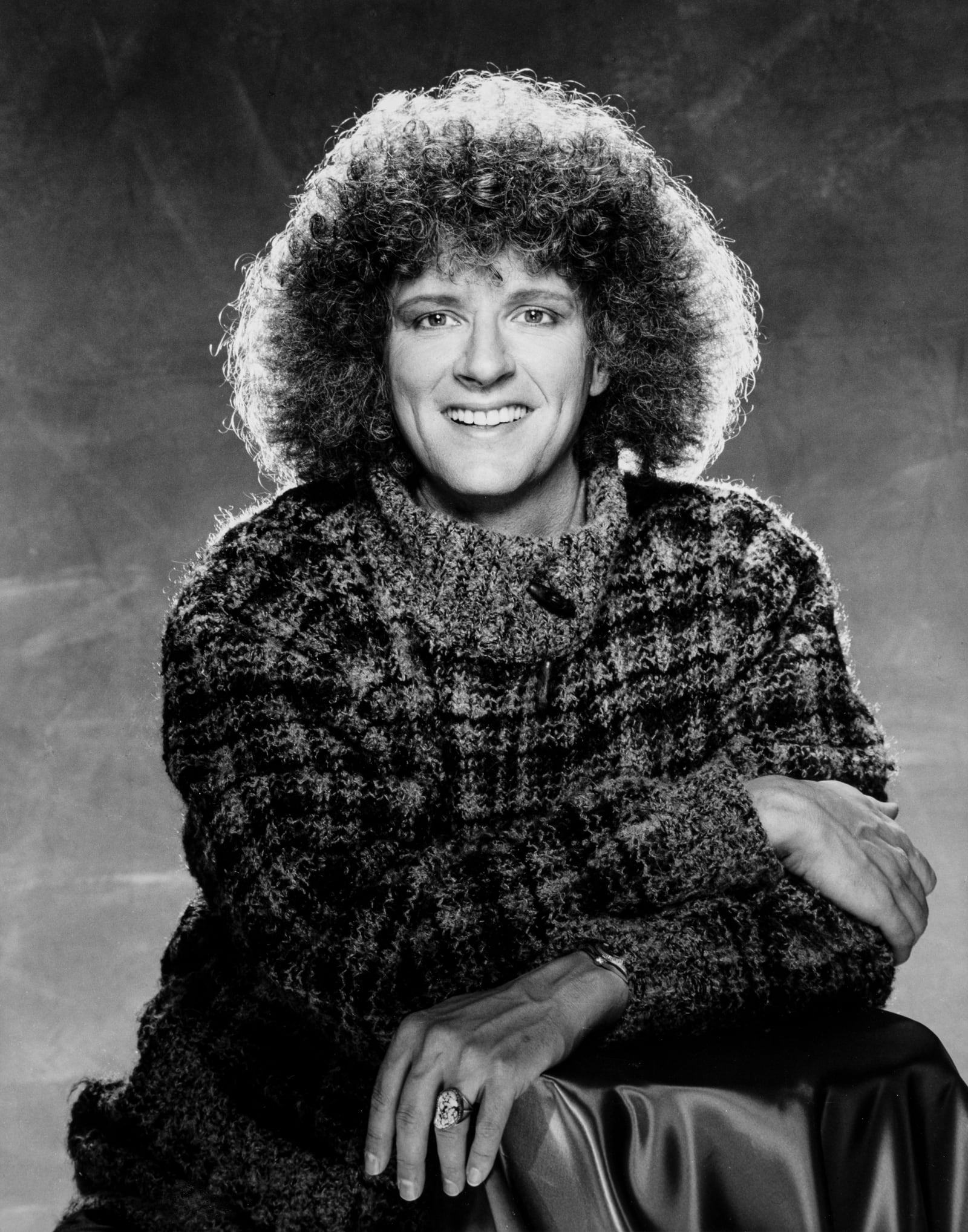 Rama smiling in a plaid tweed jacket, black and white portrait